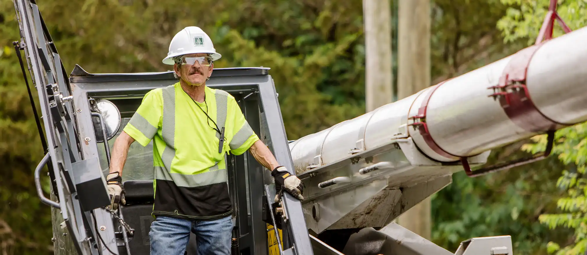 Utility crews maintaining a cleared right-of-way access road alongside transmission lines.